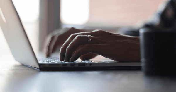 person's hand on laptop looking for divorce lawyers in the web