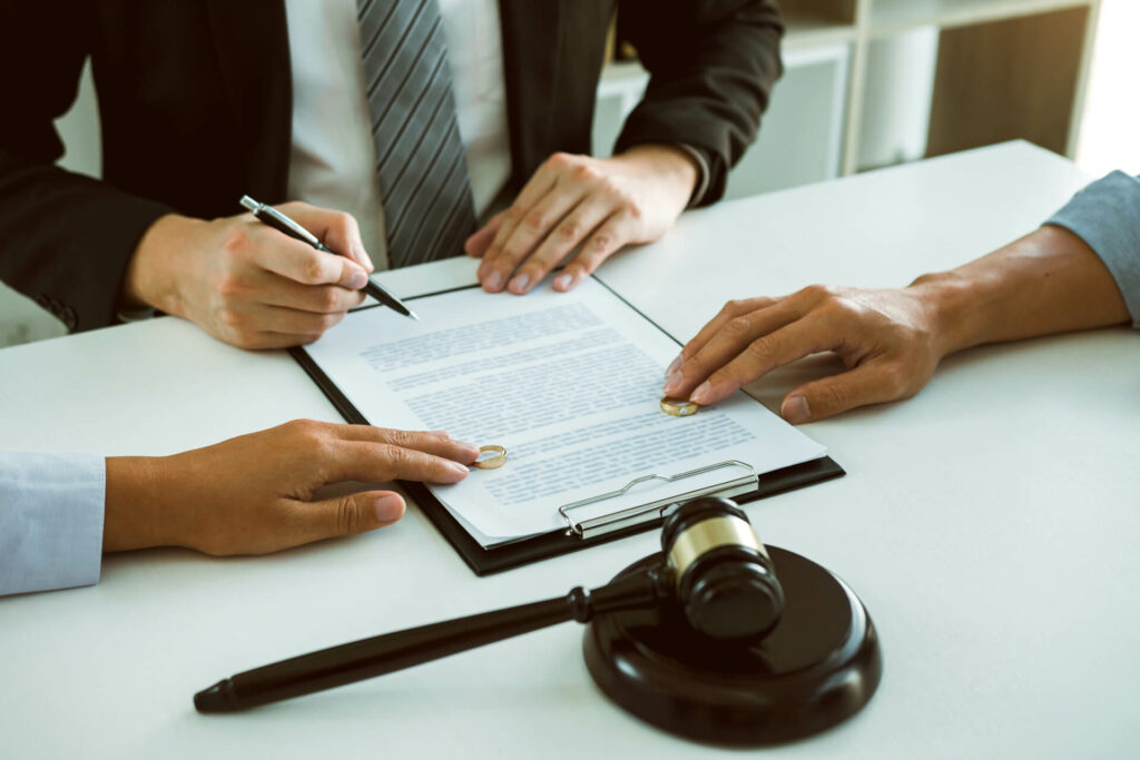 divorce attorney signing a document in front of the clients